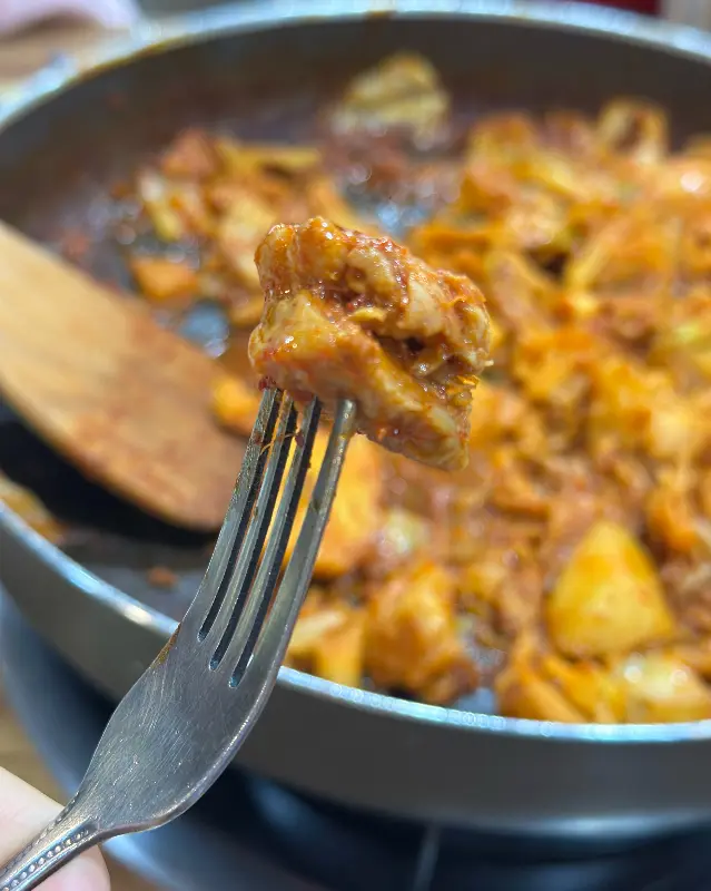 젓가락으로 닭갈비를 집어올린 모습