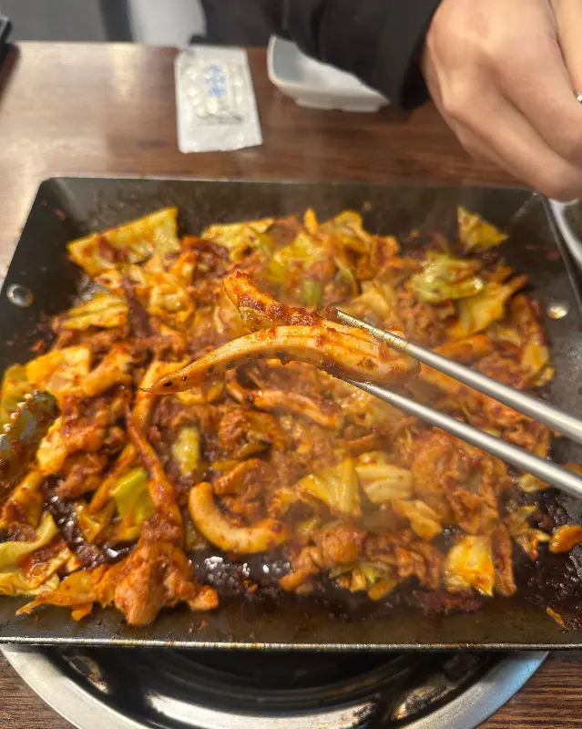 오삼불고기를 집게로 집는 모습