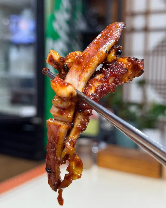 젓가락으로 집어 올린 오징어 불고기