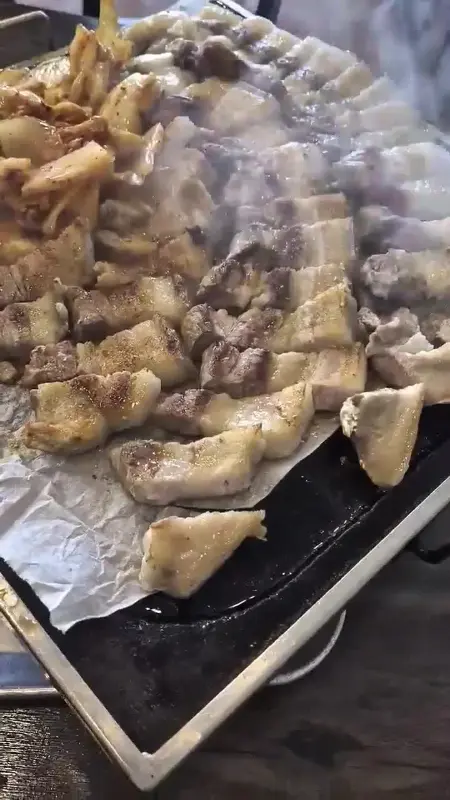 불판 위에서 익어가는 오겹살과 김치