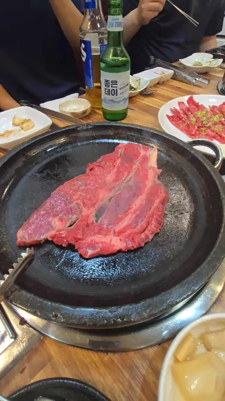 불판 위에 올려진 먹음직스러운 고기