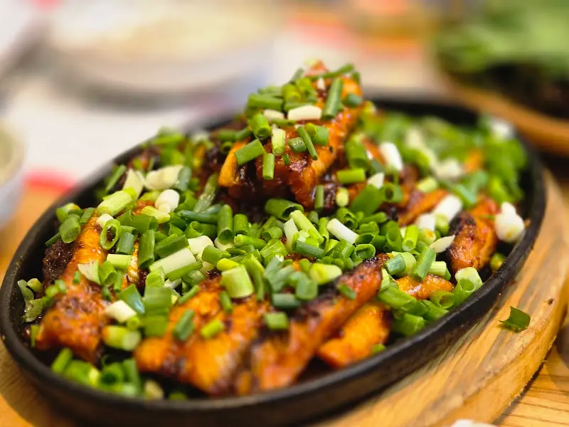 양념 장어구이 위에 쪽파가 듬뿍 올려져 있는 모습