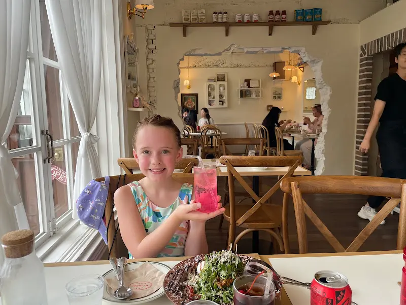 테이블에 앉아 음료를 들고 있는 아이