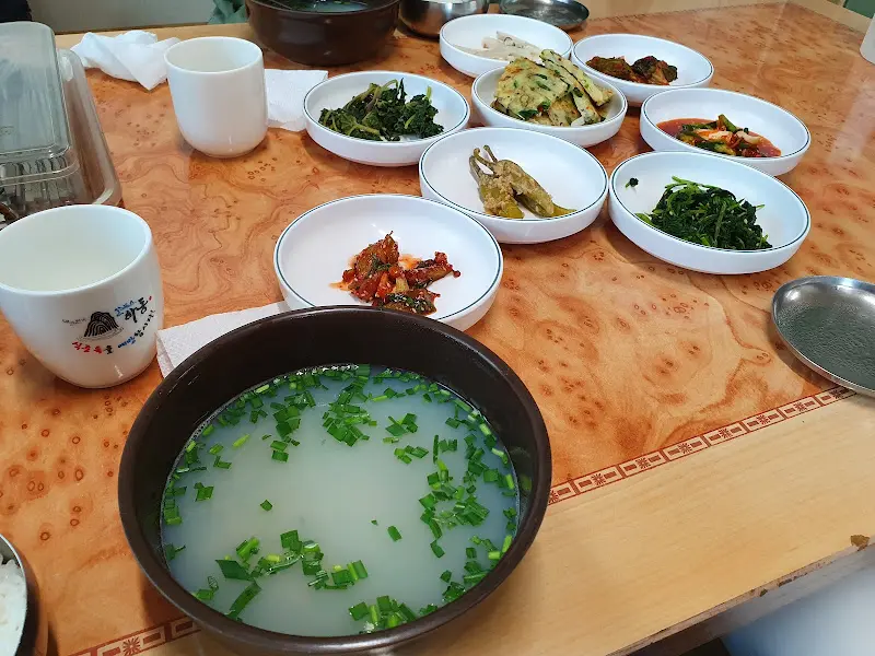 재첩국과 다양한 밑반찬이 차려진 테이블