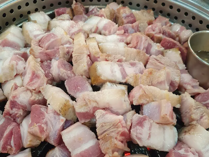 불판 위에 올려진 흑돼지 오겹살