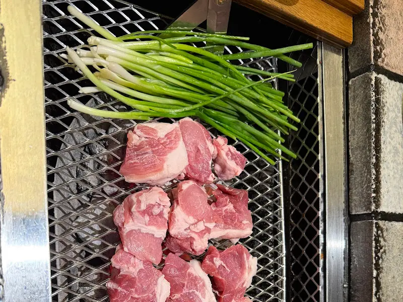 불판 위에 놓인 고기와 쪽파