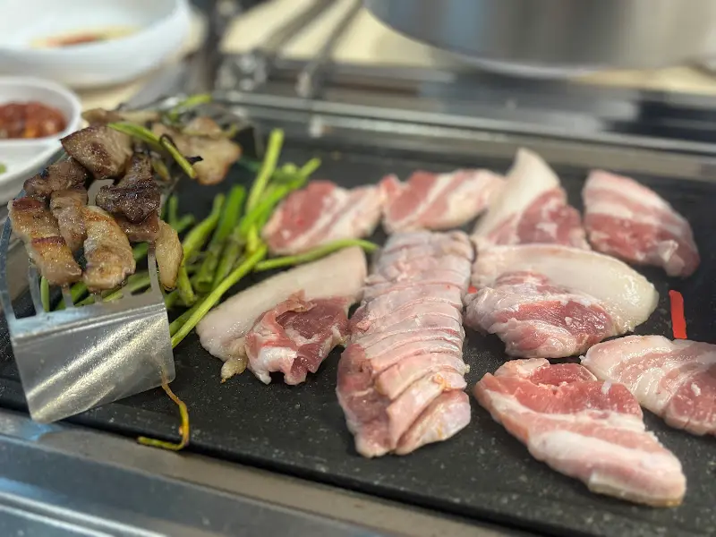 불판 가득 채운 삼겹살과 미나리