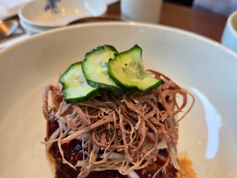 평양냉면 위에 올려진 오이 고명과 고기 고명