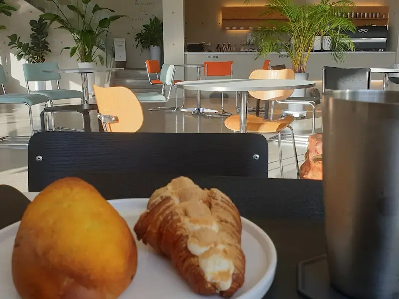 테이블 위에 놓인 빵과 음료를 담은 사진. 햇살이 따뜻하게 쏟아지는 창가 자리가 인상적이다.