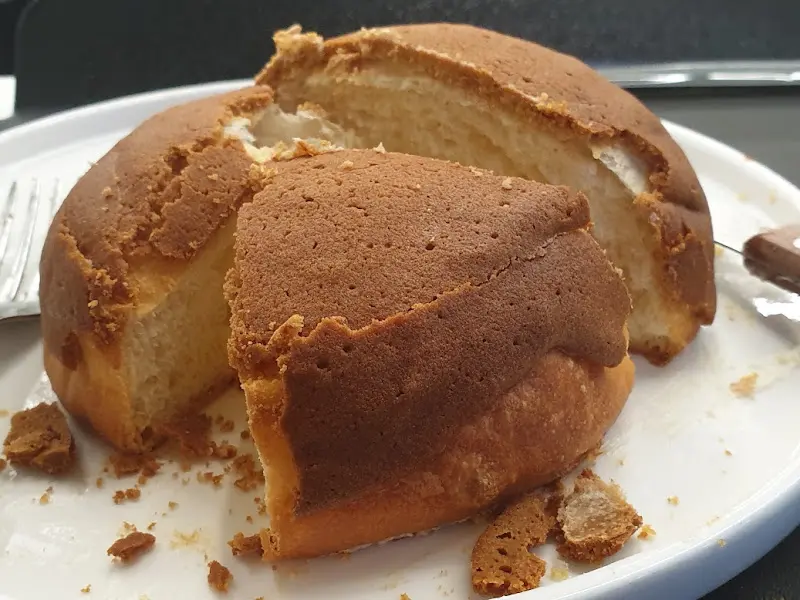 카페 내부의 테이블과 의자를 담은 사진. 넓은 창밖으로 보이는 풍경이 아름답다.