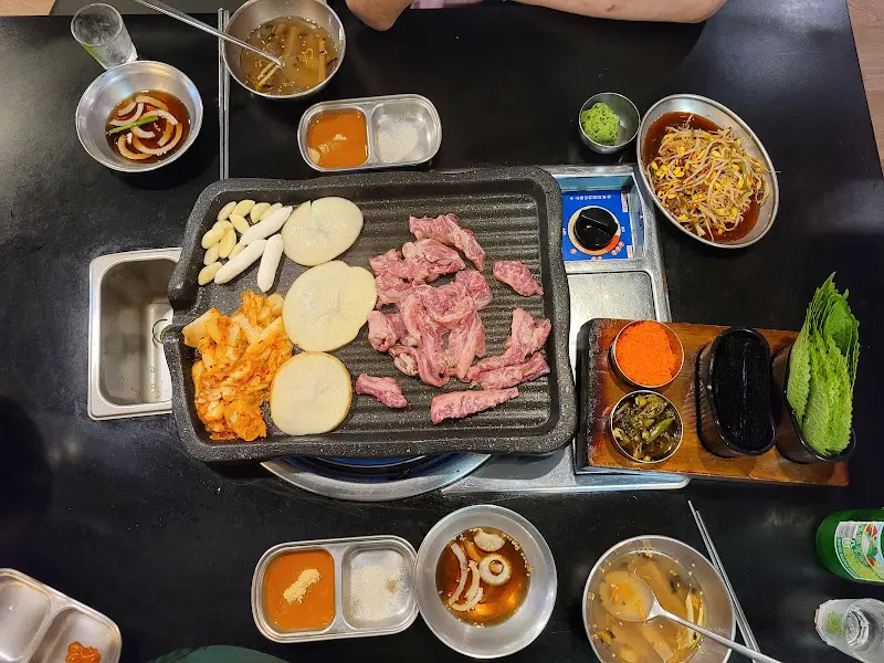 테이블 가득 차려진 고기와 다양한 밑반찬