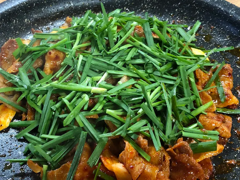 돼지구이 위에 푸짐하게 올려진 부추