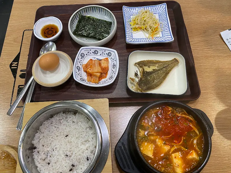 순두부찌개, 돌솥밥, 구운 생선 등이 한 상 가득 차려진 모습