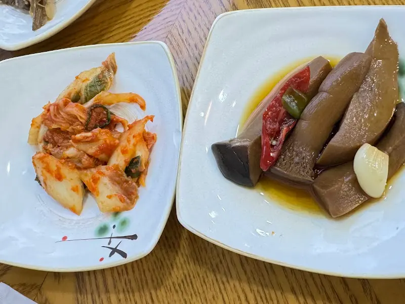 정갈하게 담긴 밑반찬들. 김치와 버섯 요리들이 보인다.