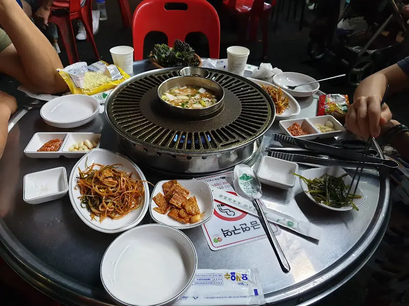 테이블 가득 차려진 푸짐한 밑반찬과 고기