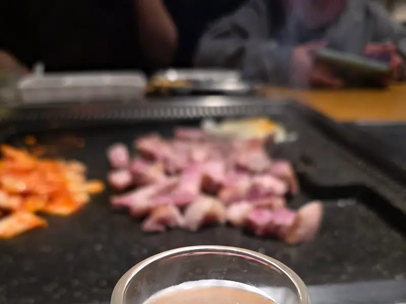 불판 가득 올려진 삼겹살과 맥주잔