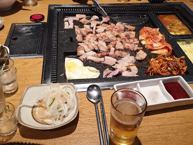 삼겹살과 김치, 콩나물, 계란이 익어가는 불판 전체샷