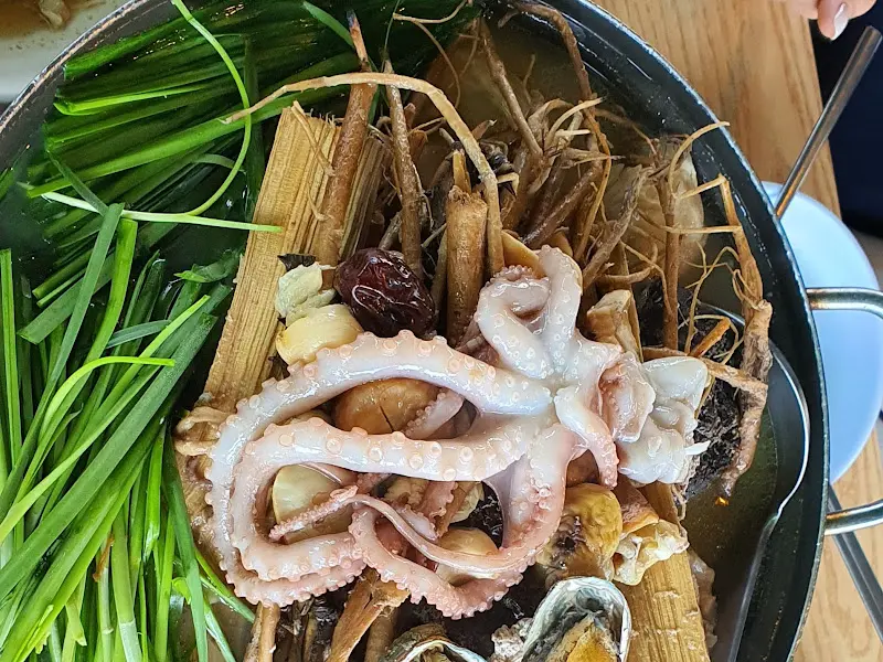 뚝배기에 담겨져 김이 모락모락 나는 닭백숙