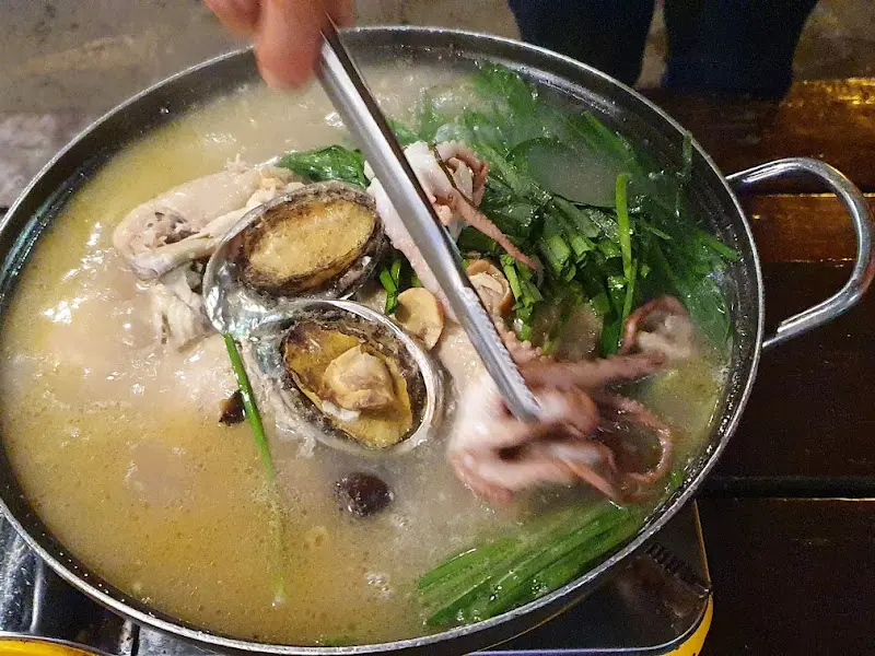 집게로 닭고기를 들어올리는 모습