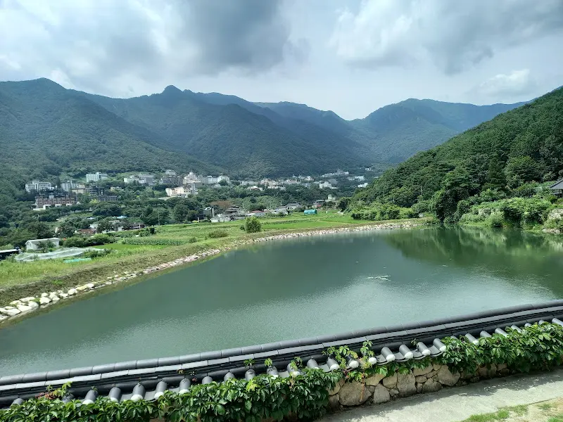 잔잔한 저수지와 그 너머로 펼쳐진 산 능선이 한눈에 들어오는 아름다운 풍경
