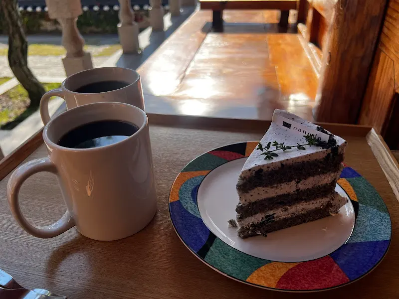 툇마루에 앉아 따뜻한 커피와 흑임자 케이크를 즐기는 모습