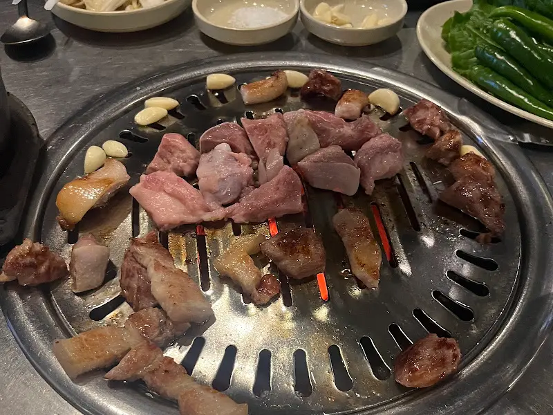 불판 위에서 맛있게 익어가는 돼지고기와 마늘