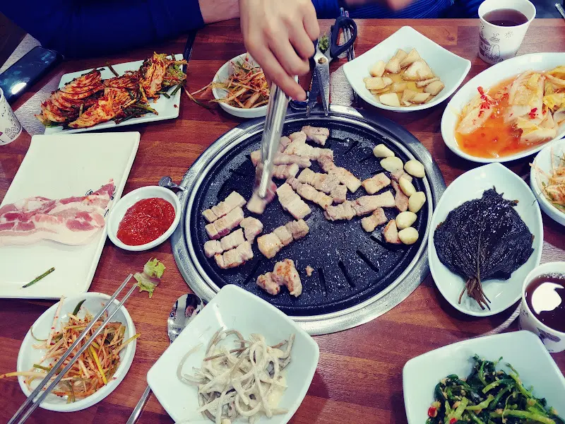 불판 위에서 맛있게 구워지는 삼겹살과 마늘