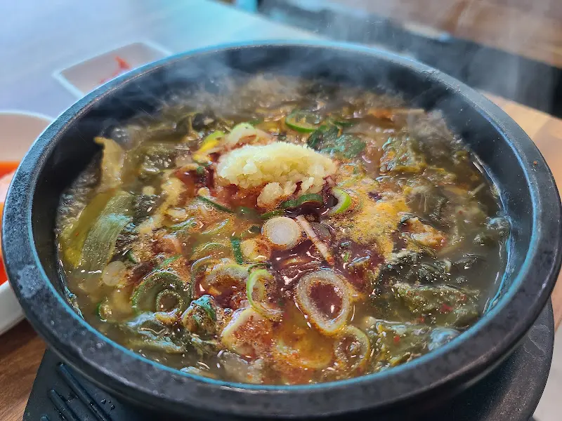 해장국에 계란과 마늘을 넣어 먹는 모습