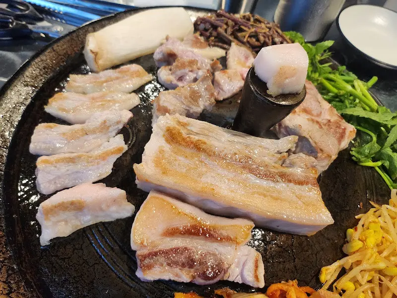 무쇠 솥뚜껑 위에서 지글거리는 제주산 돼지고기