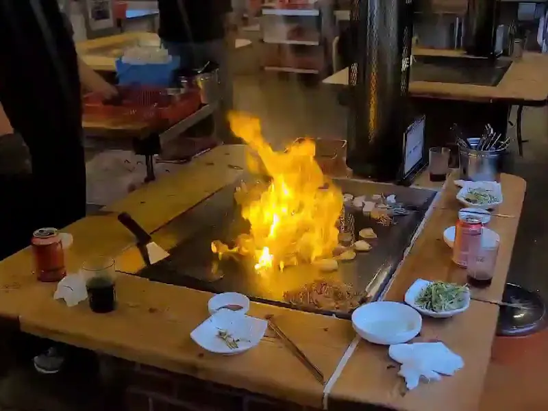 철판 위에서 삼겹살과 해산물이 함께 구워지는 모습, 다채로운 풍미를 느낄 수 있다.