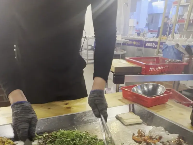 직원이 능숙하게 재료를 손질하는 모습, 신선한 재료에 대한 기대감을 높인다.