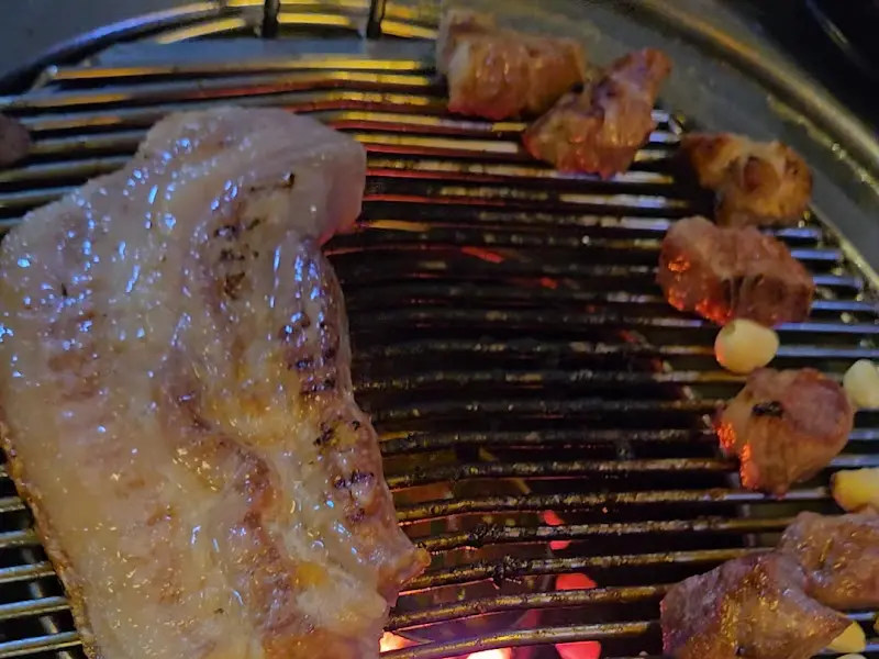 연탄불 위에서 구워지는 두툼한 고기