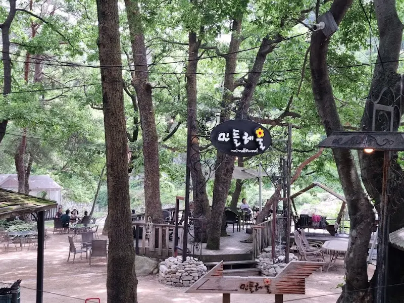 울창한 나무들 사이로 보이는 민들레울의 전경