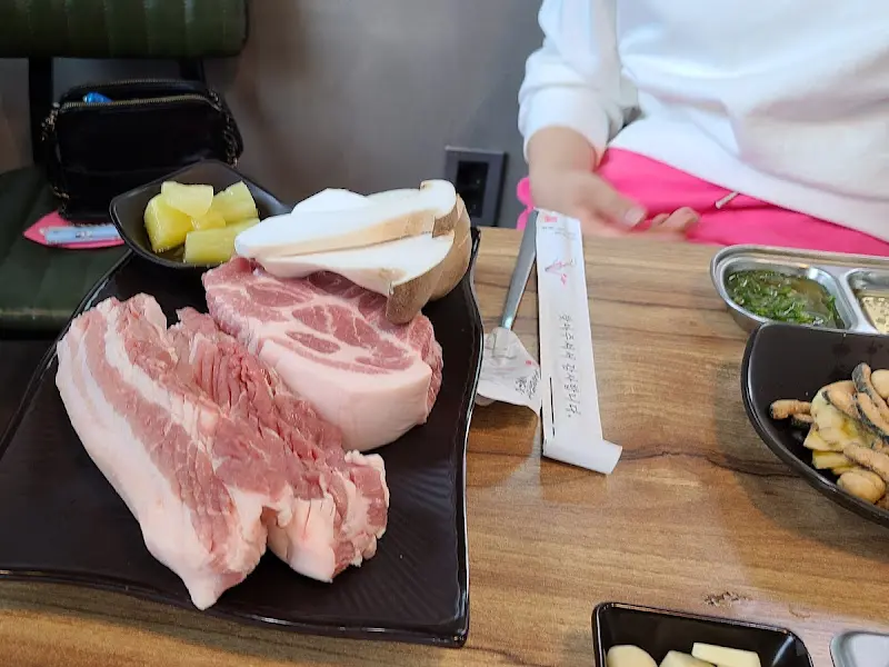 테이블 위에 놓인 삼겹살과 버섯