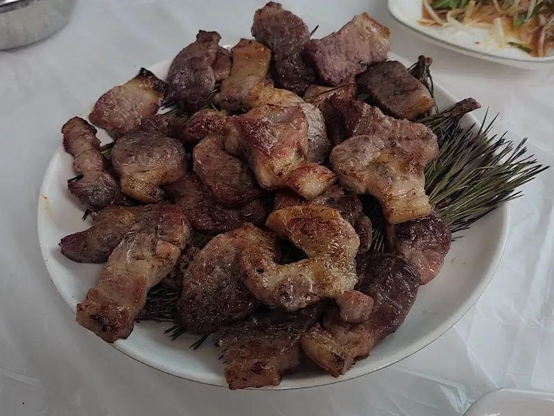 솔잎 위에 올려진 돼지숯불구이