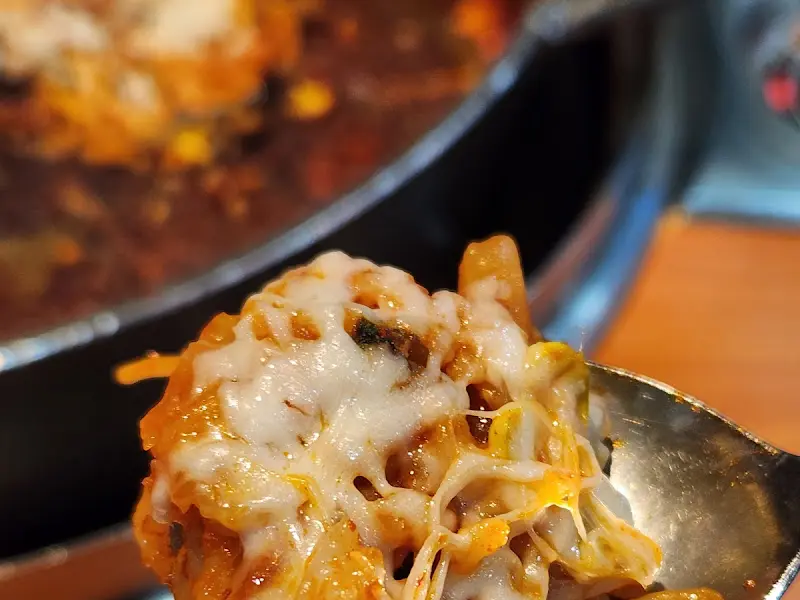 치즈 닭갈비를 숟가락으로 떠올린 모습