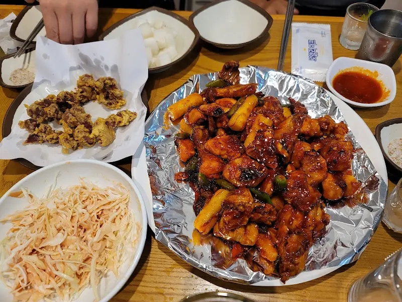 테이블 가득 차려진 숯불 치킨, 똥집 튀김, 그리고 다양한 밑반찬