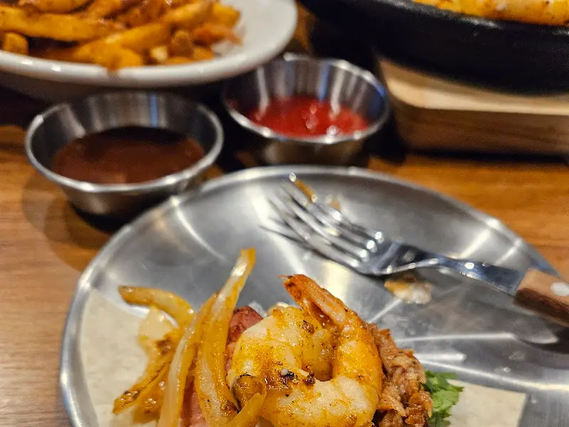 타코 위에 올려진 통통한 새우와 양파