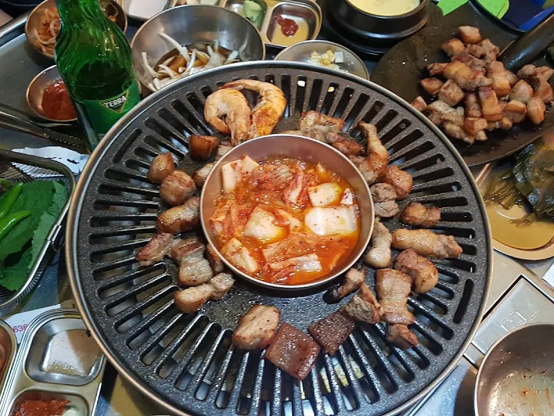 불판 위의 삼겹살과 김치찌개