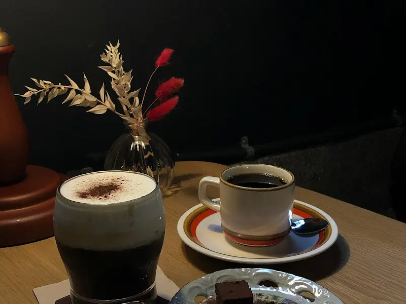 테이블 위에 놓인 커피와 초콜릿, 그리고 꽃병