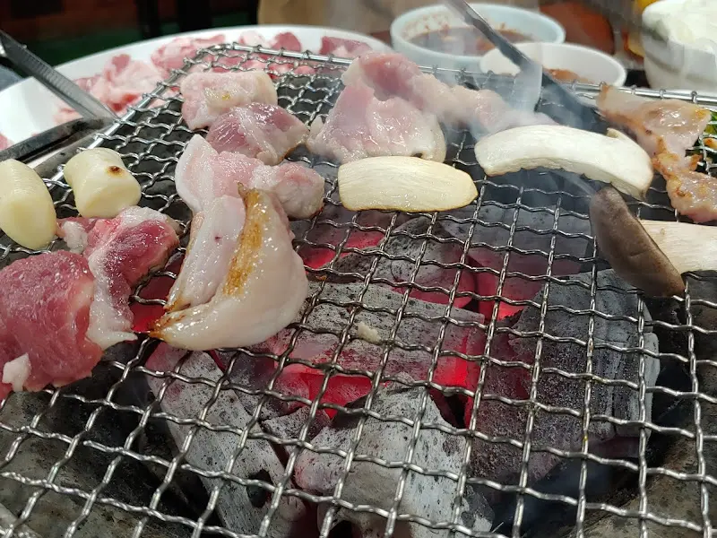 숯불과 함께 구워지는 삼겹살과 버섯, 마늘