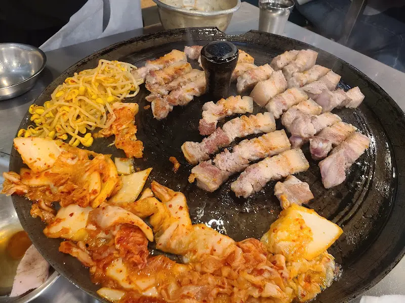 솥뚜껑 위에 올려진 목살과 김치