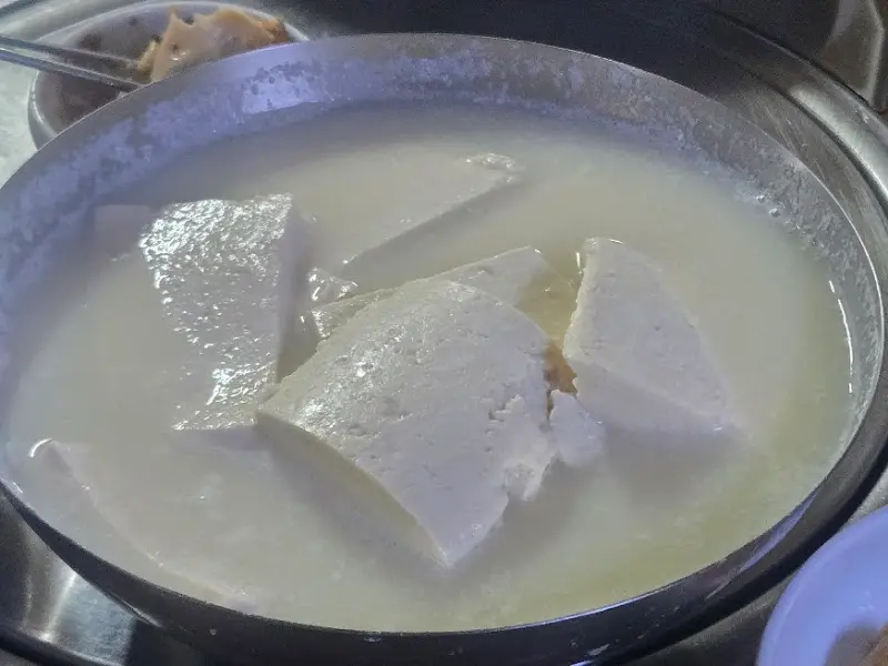 뽀얀 국물에 담긴 만두와 두부