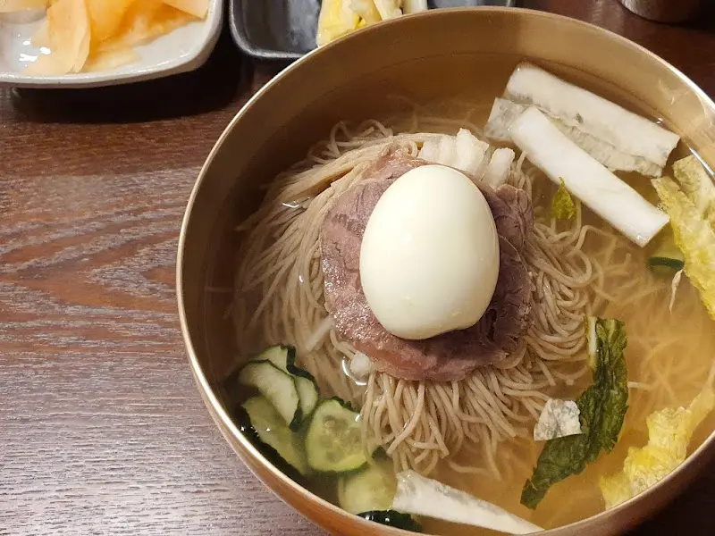 오이, 백김치, 수육, 삶은 계란이 고명으로 올려진 평양냉면