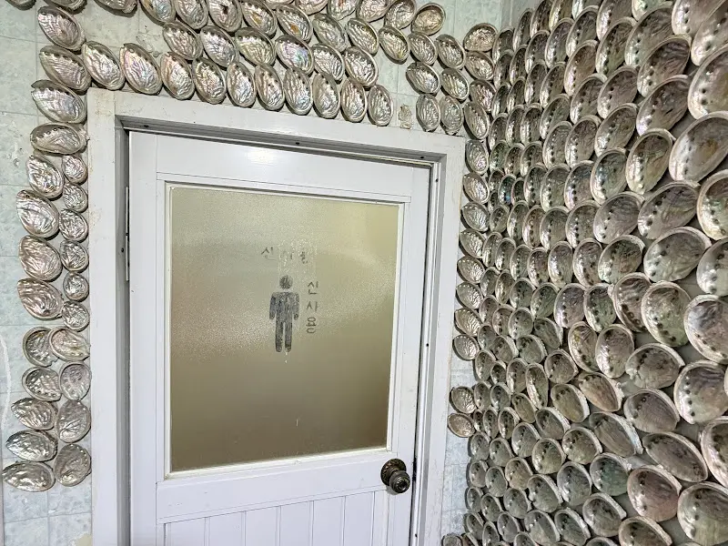 조개껍데기로 장식된 화장실 벽면