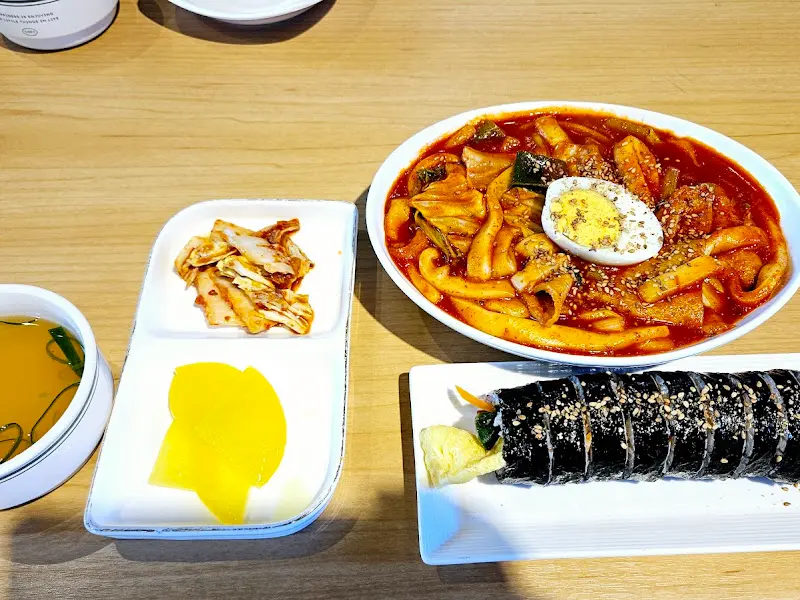 떡볶이, 김밥, 반찬이 놓인 테이블의 전체적인 모습
