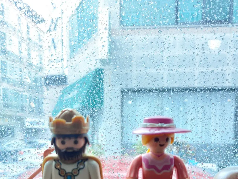 비 내리는 창밖을 바라보는 플레잉 피규어들의 모습