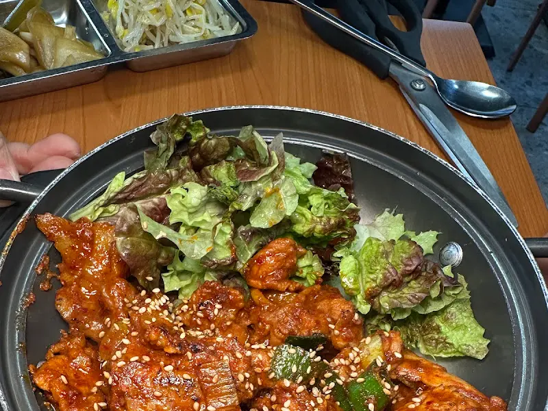 테이블 위에 놓인 제육볶음과 반찬