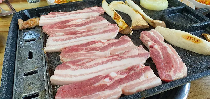 노릇하게 구워진 삼겹살과 김치, 버섯의 조화