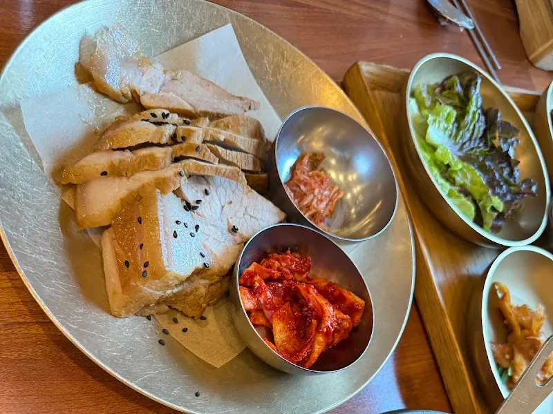 윤기가 흐르는 수육과 싱싱한 채소가 담긴 샐러드의 모습